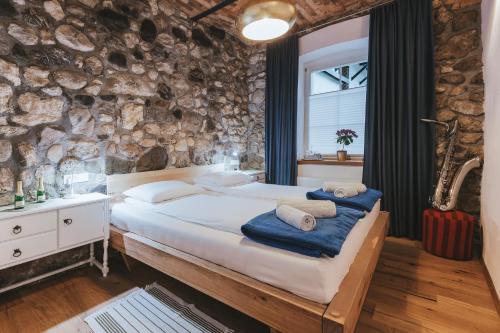 a bedroom with a large bed and a stone wall at Sobe Lotrist in Radovljica