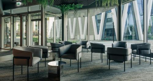 a waiting area with chairs and tables in a building at Tallink Express Hotel in Tallinn