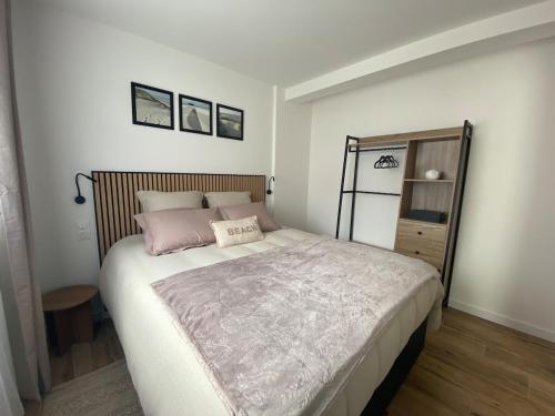 a bedroom with a large bed with pink pillows at La Cabane Marine in Sangatte
