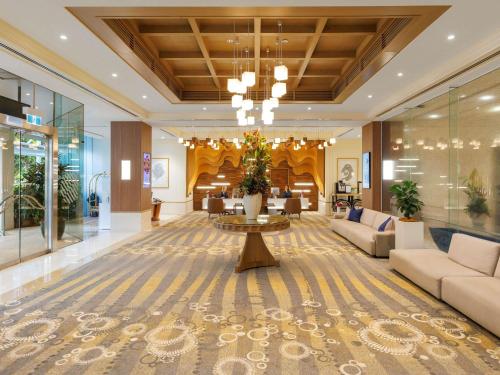 a lobby of a hotel with a couch and a table at Pullman Reef Hotel Casino in Cairns