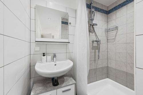 a white bathroom with a sink and a shower at City Residence - Sankt Pölten in Sankt Pölten