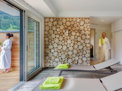 a room with a large wall of logs at Walser Lodge in Mittelberg