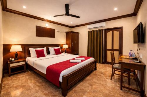 a bedroom with a bed with red pillows and a desk at Klite stays - ZomoHotels in Pondicherry