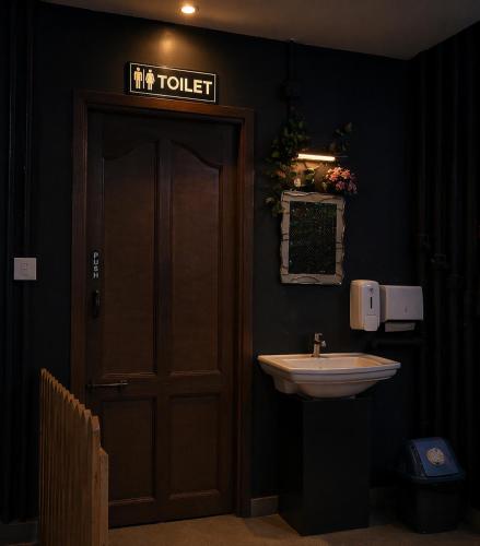 a bathroom with a door and a sink at Klite stays - ZomoHotels in Pondicherry