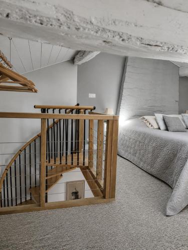 a bedroom with a staircase and a bed in a room at Gîte des Bujours in Saint-Bris-des-Bois