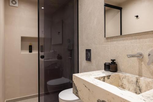 a bathroom with a sink and a toilet and a mirror at Archontiko Residence in Koskinou