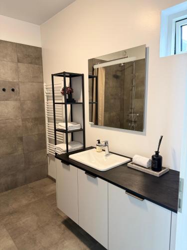 a bathroom with a sink and a mirror at New Modern Two bedroom Apartment in Hveragerði