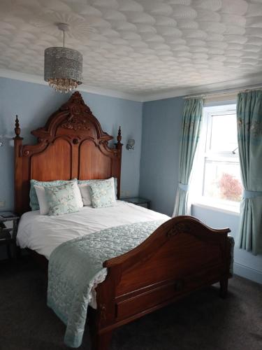 a bedroom with a large bed with a wooden headboard at Le Maitre in Southport