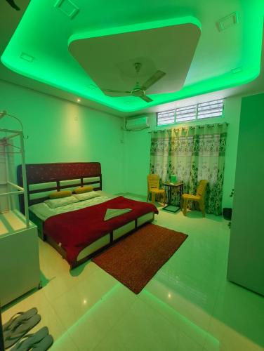 a bedroom with a red bed and a green light at Aashray Independent Homestay Dibrugarh in Dibrugarh