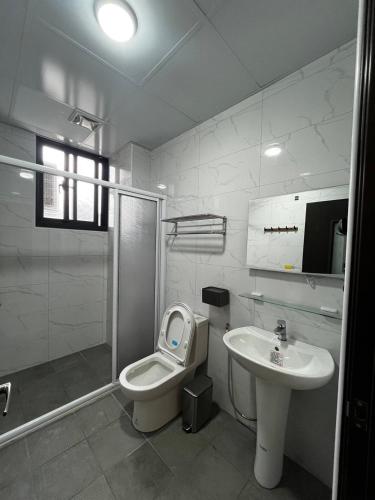 a bathroom with a toilet and a sink and a shower at Green Home in Yuli