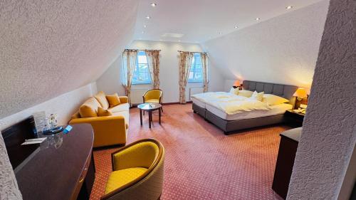 a hotel room with a bed and a living room at Hotel Lindenhof Kasteel in Mönchengladbach