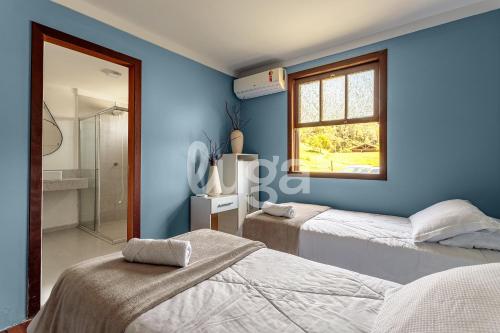 a blue bedroom with two beds and a window at Vieira Eco Inn – Flex Suite Vanir in Orleans