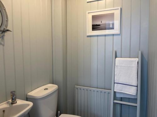 a bathroom with a white toilet and a sink at Sea Scape in Whitstable
