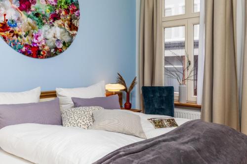 a bedroom with a large white bed with a painting on the wall at Commandeur-Huus Wohnung 1 in Borkum