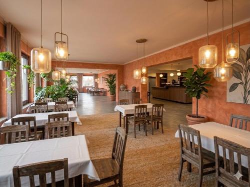 a restaurant with tables and chairs in a room at EDELFUCHS Rote-Lache in Forbach