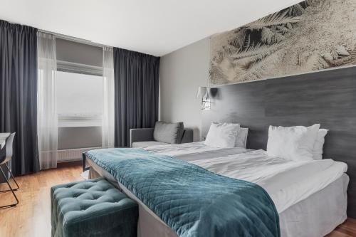 a hotel room with two beds and a couch at Quality Hotel Sundsvall in Sundsvall