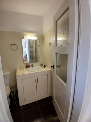 a bathroom with a white sink and a shower at Sails1 in Agia Eleousa