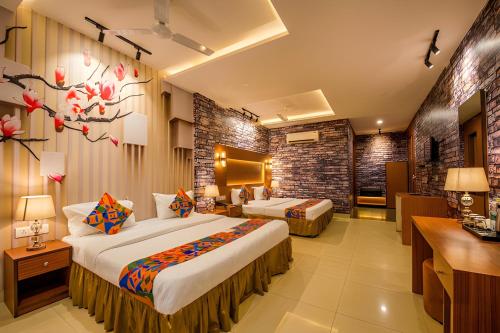 a hotel room with two beds and a desk at Hotel The Mirage in Gil