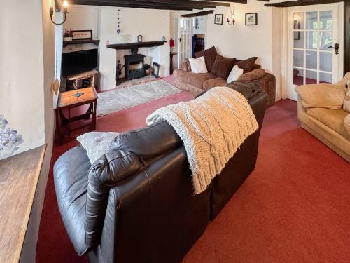 a living room with a leather couch and a fireplace at Rivers View - Uk49662 in Braunton