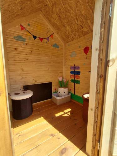 a small room with a tv in a wooden house at Relaksówka in Roztoka