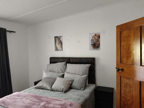 a bedroom with a bed with three pictures on the wall at The Museum in Sabie