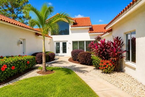 a house with a palm tree and a walkway at SWISS 24 - Lake Stephanie in Clermont