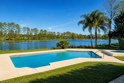 a swimming pool in front of a lake at SWISS 24 - Lake Stephanie in Clermont