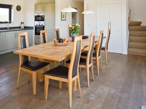 a wooden dining room table and chairs in a kitchen at The Longhouse At Threave in Castle Douglas