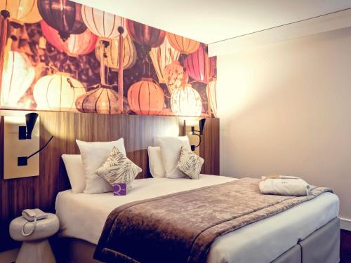 a bedroom with a bed and a wall with lanterns at Mercure Lyon Centre Plaza République in Lyon