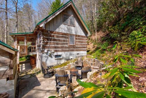 a cabin in the woods with chairs and a table at Creeksong Cabin in Elk Park