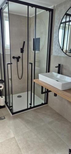 a bathroom with a shower and a white sink at Del Mar 2 in Kampor