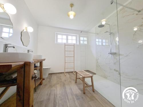 ein Badezimmer mit Dusche, Waschbecken und Hocker in der Unterkunft A Villandré in Barcugnan