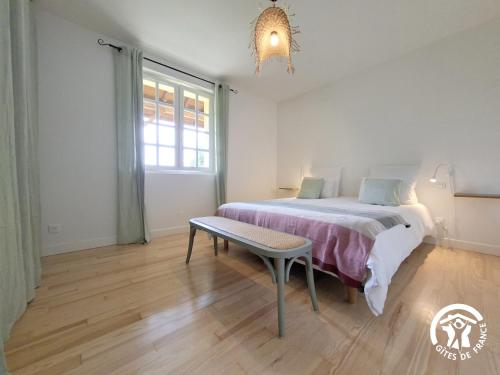 ein Schlafzimmer mit einem Bett, einer Bank und einem Fenster in der Unterkunft A Villandré in Barcugnan