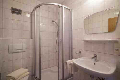 a white bathroom with a shower and a sink at Appartements Rosmarie Hollaus in Fügenberg