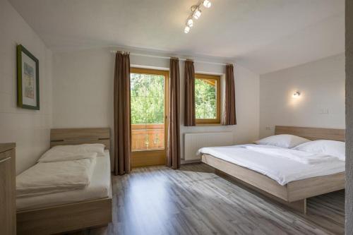 a bedroom with two beds and a window at Appartements Rosmarie Hollaus in Fügenberg
