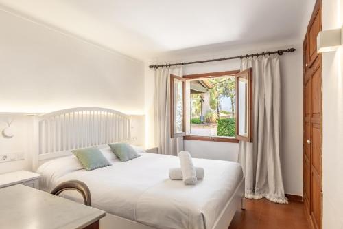 two beds in a white room with a window at Malpas in Cielo de Bonaire 