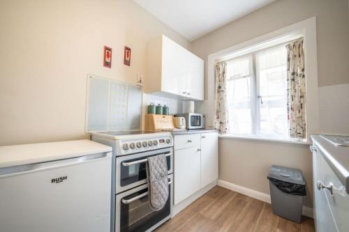 a kitchen with a stove top oven next to a window at Lelola Lodge in Bournemouth