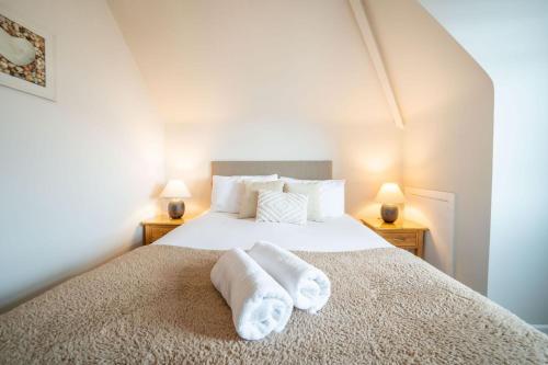 a bedroom with a bed with towels on it at Lelola Lodge in Bournemouth