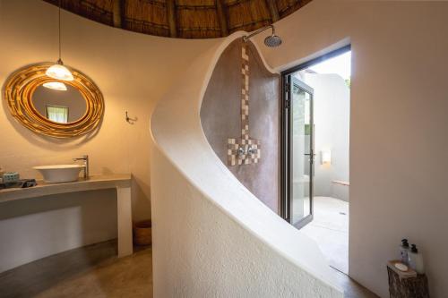 a staircase leading to a bathroom with a mirror at Nyala Safari Lodge in Hoedspruit