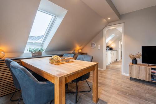 a living room with a wooden table and a tv at Pier17 Appartement 6 in Borkum