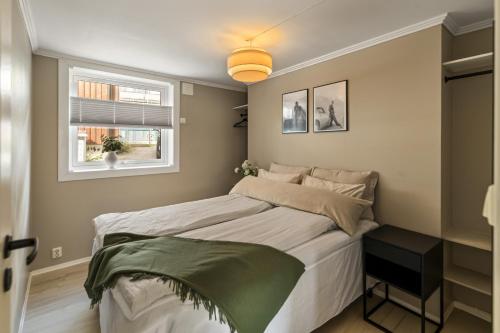 a small bedroom with a bed and a window at Koselig leilighet midt i Tønsberg in Tønsberg