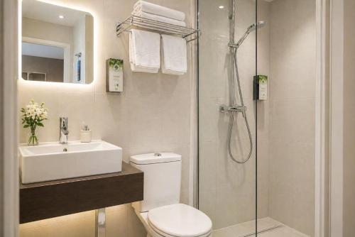 a bathroom with a shower and a toilet and a sink at Kyriad Charleville Mezieres in Charleville-Mézières