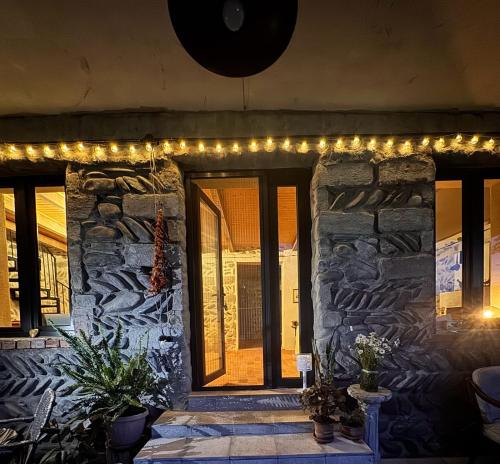 a stone building with christmas lights on it at Dusheti Retreat - Authentic Georgian Living in Dushetʼi