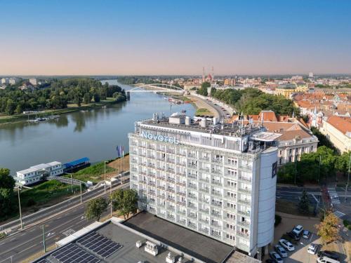 an aerial view of a building next to a river at Novotel Szeged in Szeged