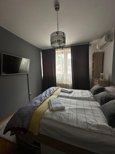 a bedroom with a large bed and a tv at Golden Apartment in Travnik
