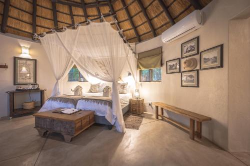 a bedroom with a bed with a canopy at Nyala Safari Lodge in Hoedspruit