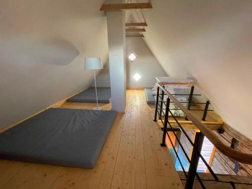 an attic room with two bunk beds and a lamp at Sunset sauna Bauska in Jumprava