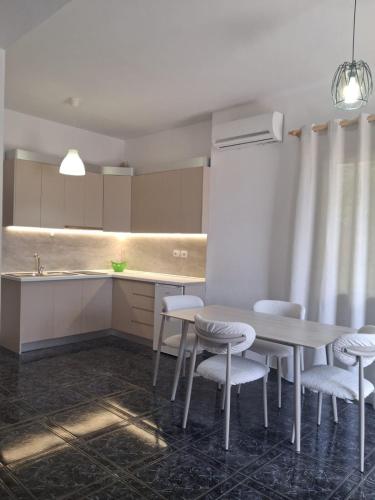 a kitchen with a table and chairs and a counter at Old Village Apartment in Dhërmi