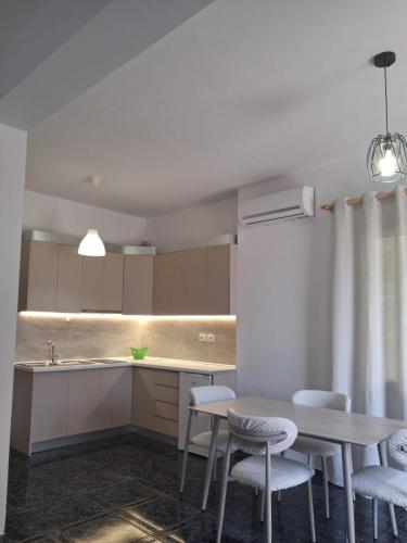 a kitchen with a table and chairs and a sink at Old Village Apartment in Dhërmi