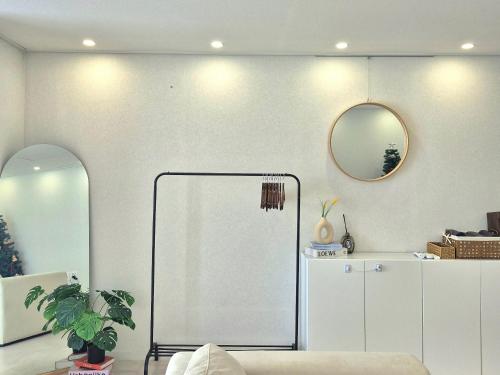 a living room with a couch and a mirror at 포포스테이 in Busan